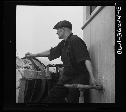 On board a fishing vessel out from Gloucester, Massachusetts. A man at the winch control