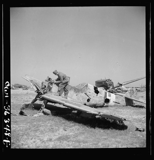 A French soldier looking over the wreckage of a German airplane at the El Aouiana airport