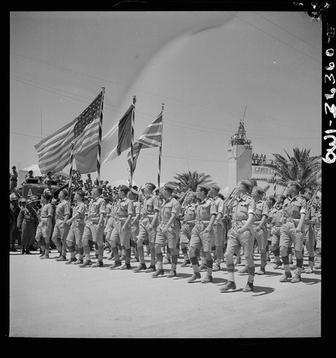 Untitled photo, possibly related to: Tunis, Tunisia. French troops passing the reviewing stand in the Allied victory parade along Avenue Gambetta as American planes fly overhead in a show of Allied might