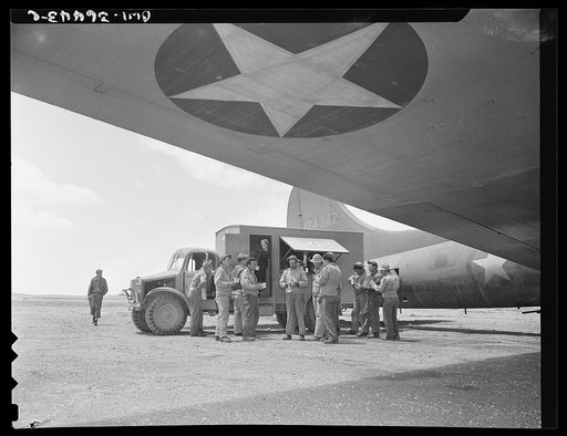 Constantine (vicinity), Algeria. A Red Cross clubmobile serving doughnuts and coffee to the crew of a bomber just returned to the airport from a dangerous mission