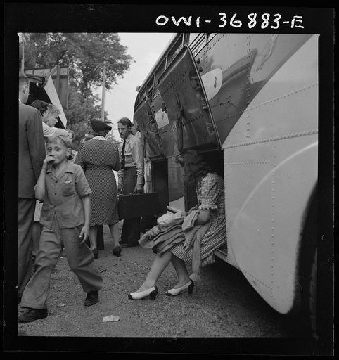 A bus driver removing the baggage from a Greyhound bus that broke down between Washington, D.C. and Pittsburgh, Pennsylvania. The girl sitting in the baggage compartment is waiting for her bag to be handed out to her