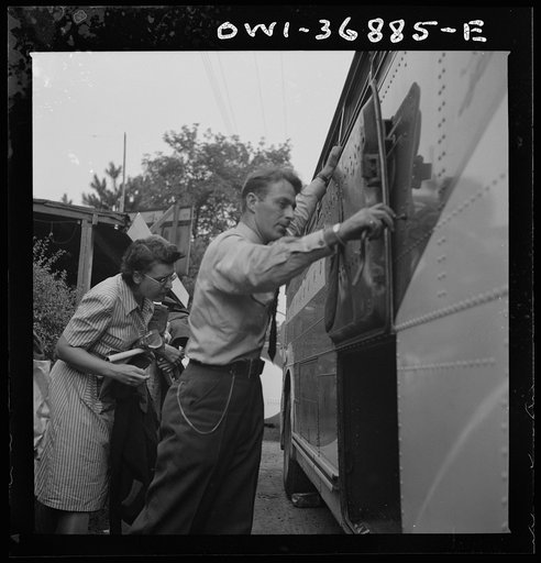 A driver getting ready to transfer the baggage from a Greyhound bus, which has broken down, to another bus in a small town in Pennsylvania