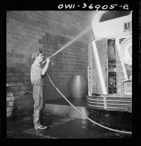 Pittsburgh, Pennsylvania. A bus serviceman washing a bus which has just come in from a run in the Greyhound garage