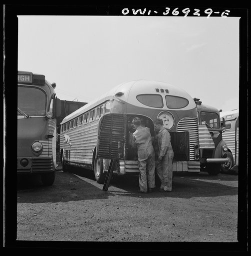 Pittsburgh, Pennsylvania. Mechanics working on a bus parked outside the Greyhound garage because there is no room inside