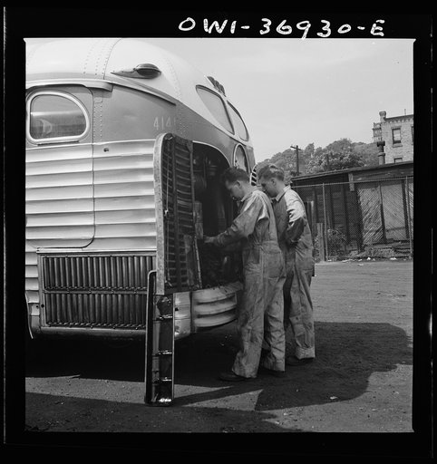 Pittsburgh, Pennsylvania. Mechanics working on a bus parked outside the Greyhound garage because there is no room inside
