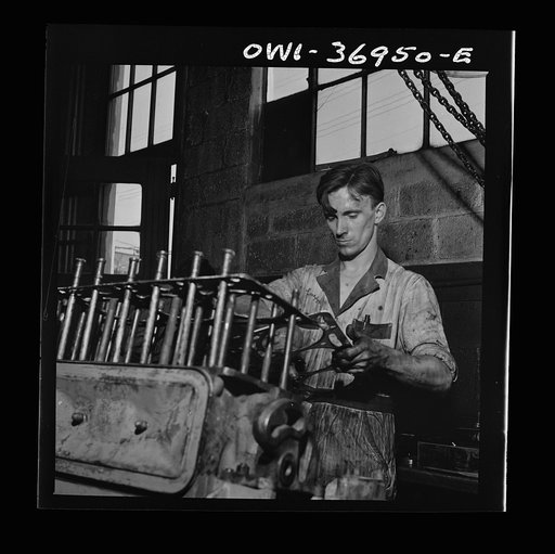 Pittsburgh, Pennsylvania. Mechanic working on a bus engine at the garage