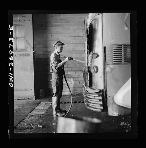 Untitled photo, possibly related to: Pittsburgh, Pennsylvania. A bus serviceman washing a bus which has just come in from a run in the Greyhound garage