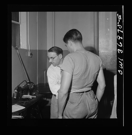 Untitled photo, possibly related to: Pittsburgh, Pennsylvania. A tailor fitting a coat at the shop maintained in the Greyhound garage. Drivers pay a dollar a month and can have clothes altered, fitted, and pressed at any time