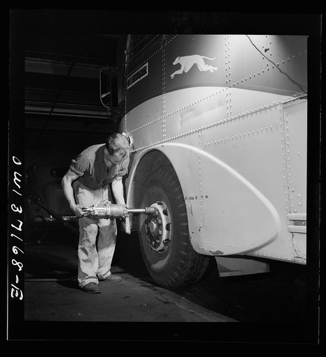 Pittsburgh, Pennsylvania. Removing a tire from a bus at the Greyhound garage