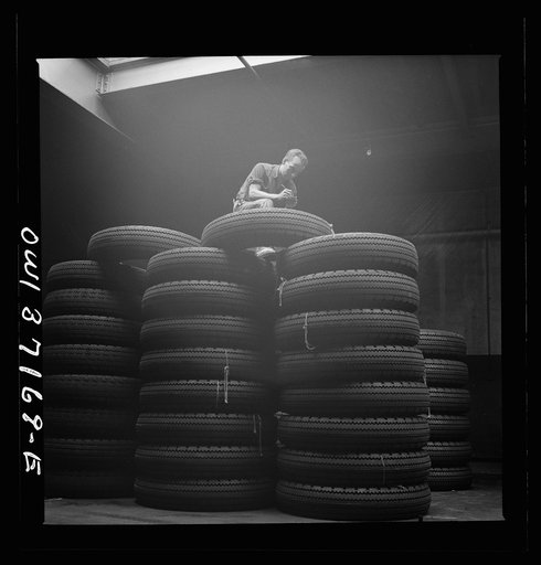 Untitled photo, possibly related to: Pittsburgh, Pennsylvania. Checking brand numbers on new tires at the Greyhound garage