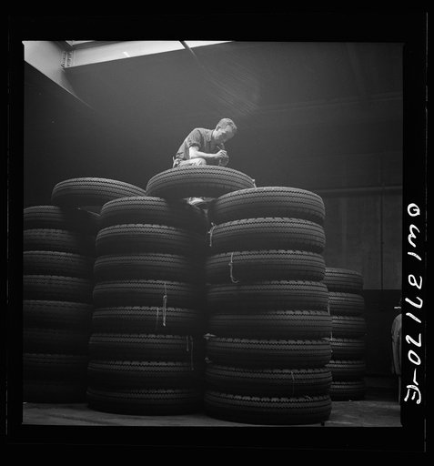 Pittsburgh, Pennsylvania. Checking brand numbers on new tires at the Greyhound garage