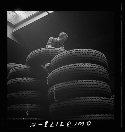 Untitled photo, possibly related to: Pittsburgh, Pennsylvania. Checking brand numbers on new tires at the Greyhound garage