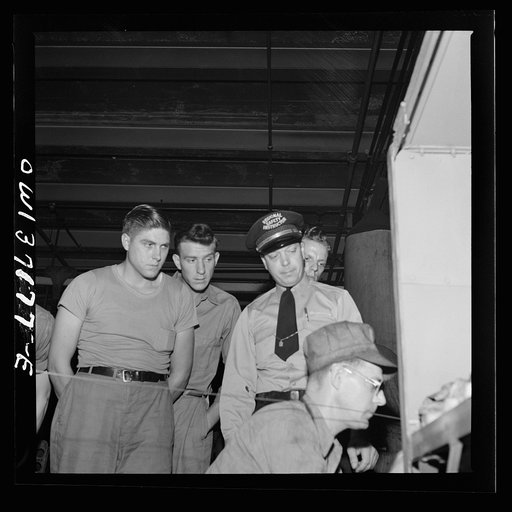 Untitled photo, possibly related to: Pittsburgh, Pennsylvania. The regional safety instructor for the Greyhound bus company showing a group of new drivers one of the machines in the machine shop at the Greyhound garage