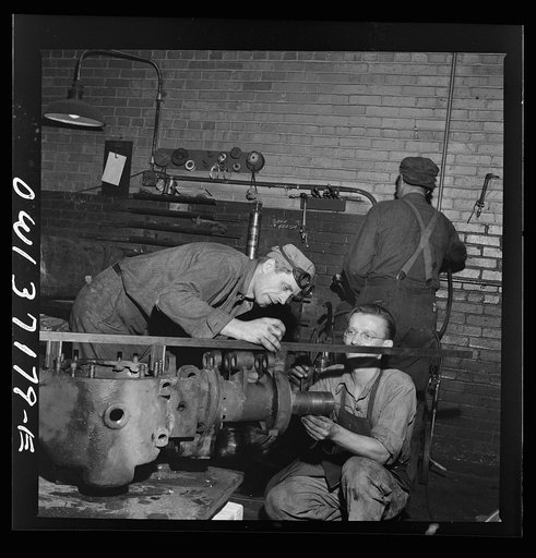 Pittsburgh, Pennsylvania. A mechanic working on a rear axle housing at the Greyhound garage