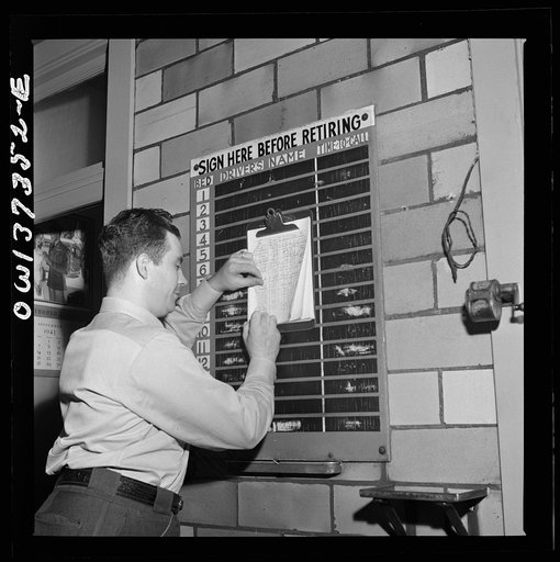 Pittsburgh, Pennsylvania. A Greyhound bus driver signing in for a bed at the dormitory in the garage. A porter checks the list and calls the drivers in time for their runs