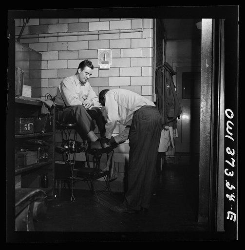 Untitled photo, possibly related to: Pittsburgh, Pennsylvania. A Greyhound driver getting his shoes shined by a porter at the garage