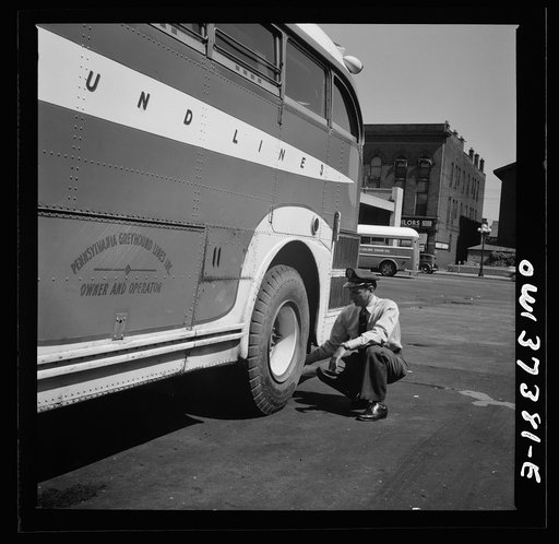 Columbus, Ohio. Randy Pribble, a bus driver for the Pennsylvania Greyhound Lines, Incorporated, checking tires on a bus by thumping them before taking it out on a run. Since there are two tires on the back, the sound is the best way of telling if one is flat