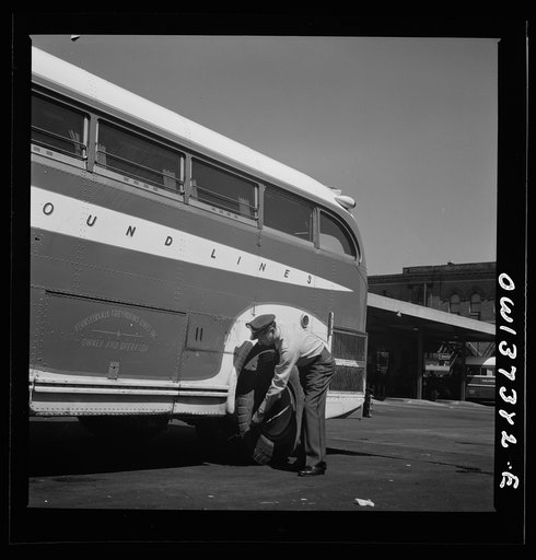 Columbus, Ohio. Randy Pribble, a bus driver for the Pennsylvania Greyhound Lines, Incorporated, checking tires on a bus by thumping them before taking it out on a run. Since there are two tires on the back, the sound is the best way of telling if one of them is flat