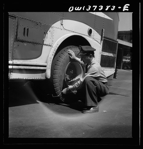 Columbus, Ohio. Randy Pribble, a bus driver for the Pennsylvania Greyhound Lines, Incorporated, checking tires on a bus by thumping them before taking it out on a run. Since there are two tires on the back, the sound is the best way of telling if one of them is flat