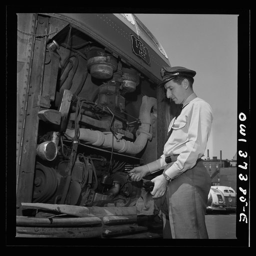 Columbus, Ohio. Randy Pribble, a bus driver for the Pennsylvania Greyhound Lines, Incorporated, checking the oil in a bus before taking it out on a run
