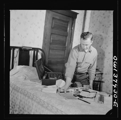 Pittsburgh, Pennsylvania. Clem Carson, a Greyhound bus driver, packing the suitcase which he takes with him on a run