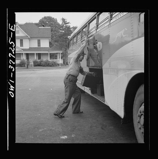 A Greyhound bus driver loading baggage at a small town between Chicago, Illinois and Cincinnati, Ohio