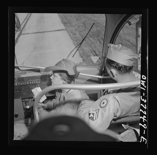 A girl riding in the jump seat which was originally meant for the porter, because standing room in the aisles is taken on a Greyhound bus going from Chicago, Illinois to Cincinnati, Ohio