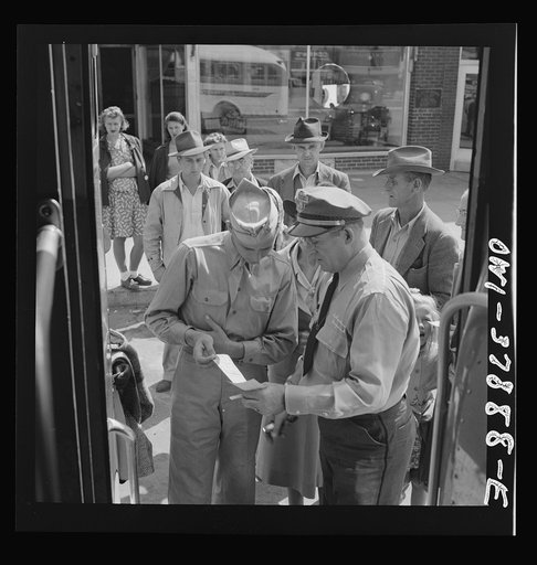 A Greyhound bus trip from Louisville, Kentucky, to Memphis, Tennessee, and the terminals. Soldier checking ticket with the bus driver before getting on at a small town in Georgia