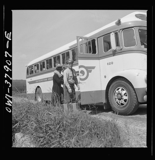 A Greyhound bus trip from Louisville, Kentucky, to Memphis, Tennessee, and the terminals. Greyhound driver helping woman with her bag. From a nearby farm, she flagged the bus on the highway