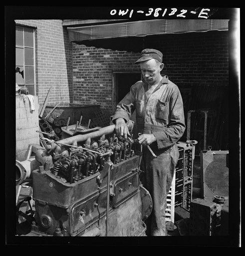 Bus trip from Knoxville, Tennessee, to Washington, D.C. Mechanic working on motor outside of garage of Tennessee Coach Company, Knoxville