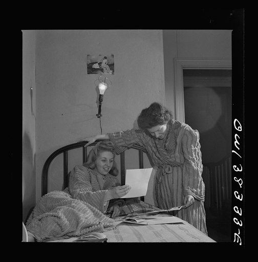 Washington, D.C. Two girls looking at pictures in their room in a boardinghouse