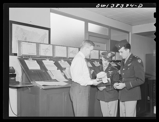 Washington, D.C. The U.S. Weather Bureau station at the National Airport. Weather information is essential to all aircraft pilots. Here the forecaster is shown discussing the type of weather the pilots may encounter on their proposed flights