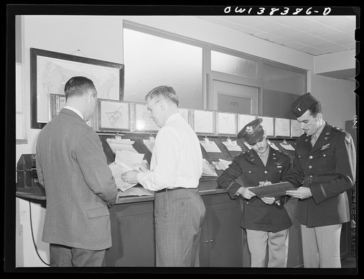 Washington, D.C. The U.S. Weather Bureau station at the National Airport. Weather information is essential to all aircraft pilots. Here the forecaster is shown discussing the type of weather the pilots may encounter on their proposed flights
