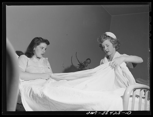Washington, D.C. A high school student nurse's aide adjusting the covers for a patient at emergency hospital