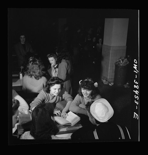 Washington, D.C. Girls in the cafeteria flock around a sailor who graduated in June and is spending part of his first leave visiting Woodrow Wilson High School