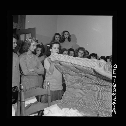 Washington, D.C. Students in a home management class at Woodrow Wilson High School showing how to turn a mattress. The school has a model bedroom for use in such demonstrations