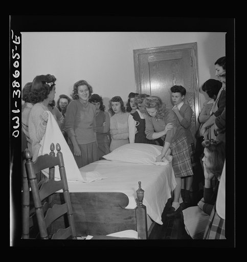 Washington, D.C. Home management students at Woodrow Wilson High School giving a demonstration in bedmaking. There is a model bedroom, living room, kitchen, and laundry for use by home economics students
