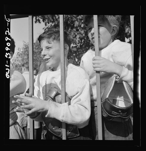 Washington, D.C. Young football fans, unable to finance a ticket to the Woodrow Wilson High School-Georgetown Preparatory School game, watching it through the fence at Woodrow Wilson High School