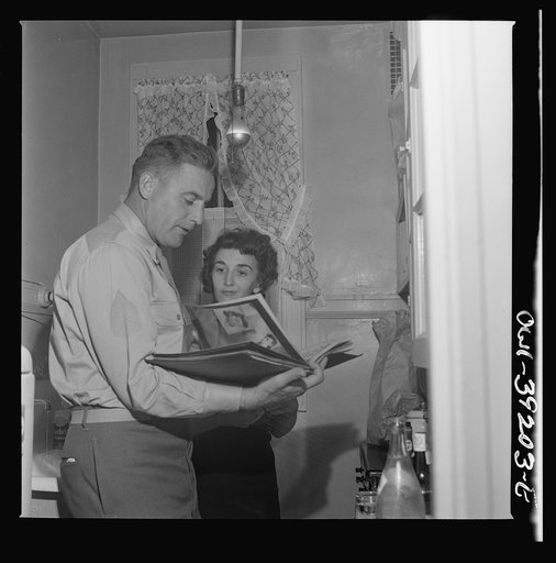 Washington, D.C. Serviceman and a girl looking at pictures at a party