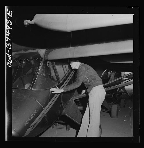 Frederick, Maryland. Walter Spangenberg, a student at Woodrow Wilson High School, inspecting one of the planes stored at the Stevens airport. Building model planes is one of his hobbies and he takes every chance to make a detailed inspection of any type of aircraft