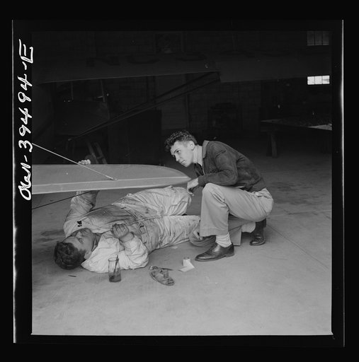 Frederick, Maryland. Walter Spangenberg, a student at Woodrow Wilson High School, watches a mechanic repairing a plane at the Stevens Airport