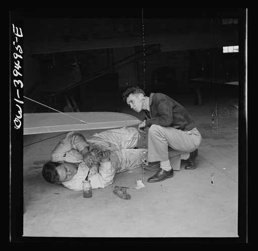 Untitled photo, possibly related to: Frederick, Maryland. Walter Spangenberg, a student at Woodrow Wilson High School, watches a mechanic repairing a plane at the Stevens Airport