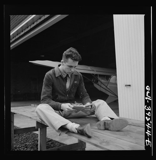Untitled photo, possibly related to: Frederick, Maryland. Walter Spangenberg, a student at Woodrow Wilson High School, studying his English lesson while waiting to fly at the Stevens Airport
