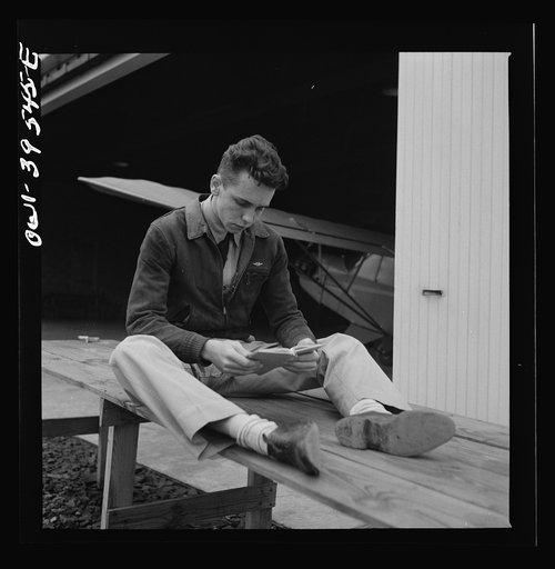 Frederick, Maryland. Walter Spangenberg, a student at Woodrow Wilson High School, studying his English lesson while waiting to fly at the Stevens Airport
