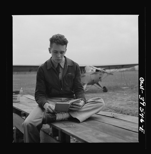 Frederick, Maryland. Walter Spangenberg, a student at Woodrow Wilson High School, studying his English lesson while waiting to fly at the Stevens Airport