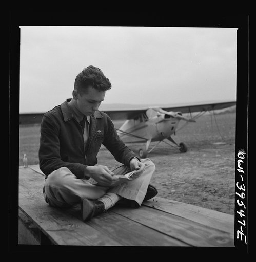 Untitled photo, possibly related to: Frederick, Maryland. Walter Spangenberg, a student at Woodrow Wilson High School, studying his English lesson while waiting to fly at the Stevens Airport