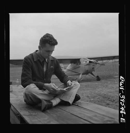 Frederick, Maryland. Walter Spangenberg, a student at Woodrow Wilson High School, studying his English lesson while waiting to fly at the Stevens Airport