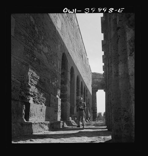 Syracuse (vicinity), Sicily. A girl standing in the doorway of her makeshift home in the ruins of a Roman amphitheatre