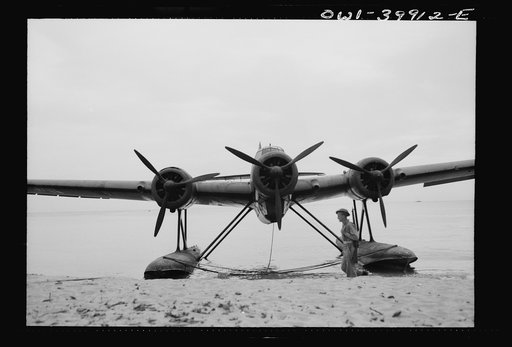 An Italian seaplane on a Sicilian beach guarded by a British soldier