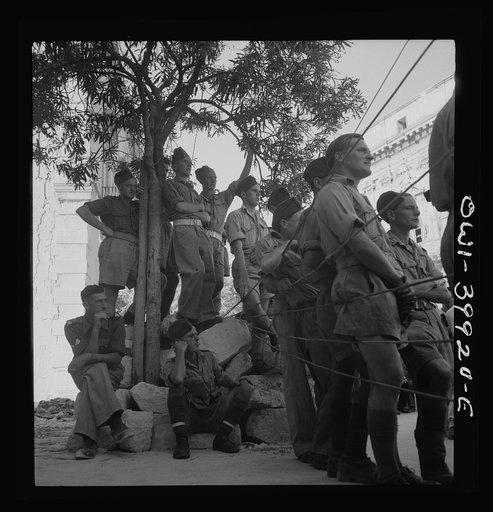 Allied soldiers and Sicilian civilians listening to a band concert